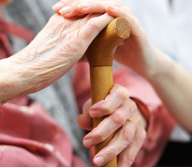 An elderly person holding a cane.